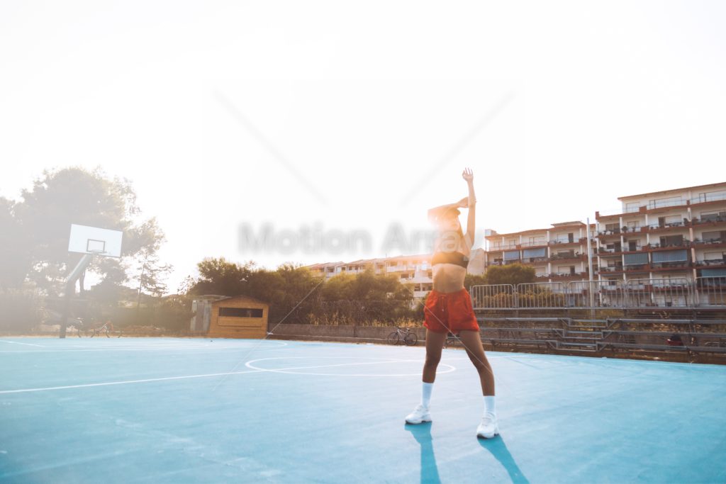 Woman stretching on a basketball court